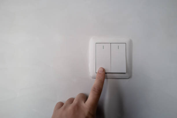 istock The hand of the white switch pressed on the white wall 1391036110