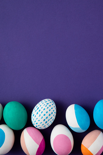 Painted colorful easter eggs on purple background