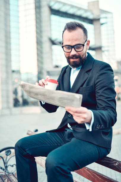 istock Coffee And Newspaper Break For Bearded Businessman 1391043097