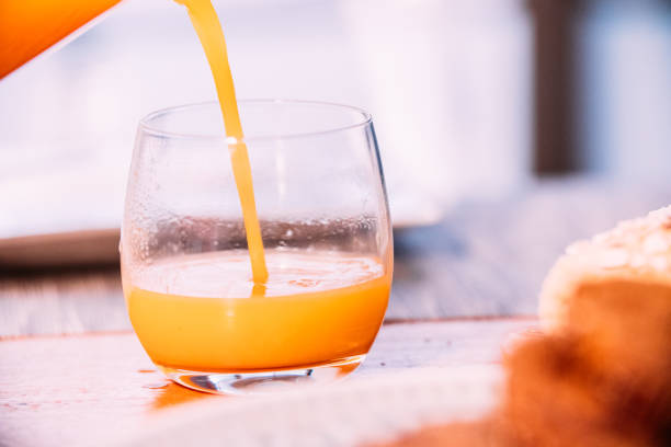 istock Pouring orange juice into a glass. Close-up 1391043832