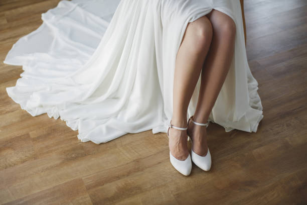 istock bride puts on white shoes on feet. 1391044886