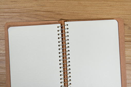 Blank spiral notebook on wood background