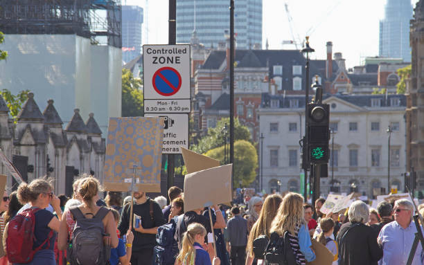 multidões de manifestantes contra a mudança climática em uma marcha de protesto do extinction rebellion em londres. - protestor protest sign strike - fotografias e filmes do acervo