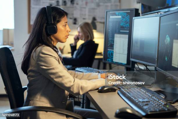 Side View Of Young Hispanic Female Operator Of Surveillance System Stock Photo - Download Image Now