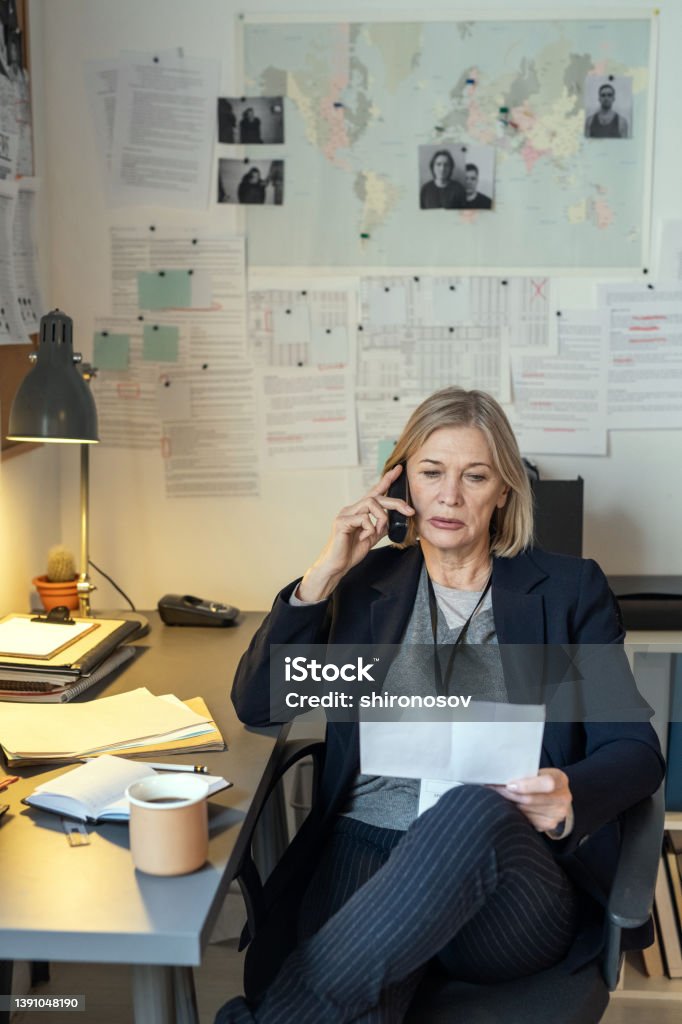 Blond Female Detective Sitting In Office And Questioning Witness On The Blond Female Detective Sitting In Office And Questioning Witness On The