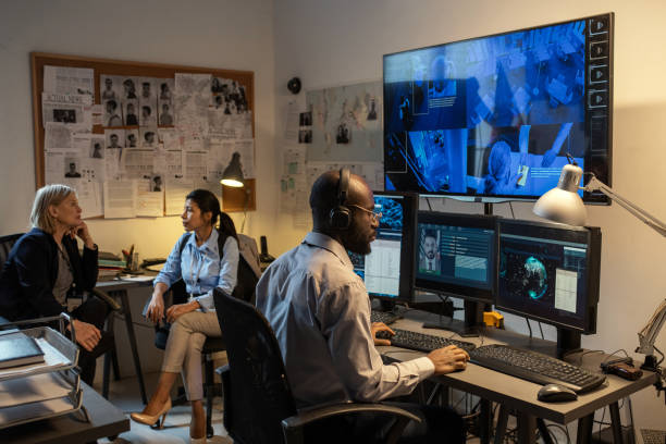 agente afro-americano do fbi sentado na frente de monitores de computador e tela - ciência forense - fotografias e filmes do acervo