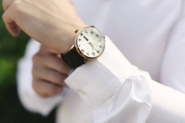 istock Close-up hands of the groom with a clock. 1391050194