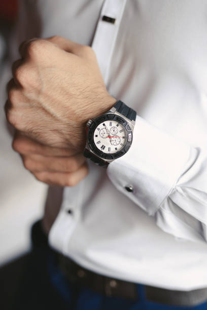 istock Close-up hands of the groom with a clock. 1391050213