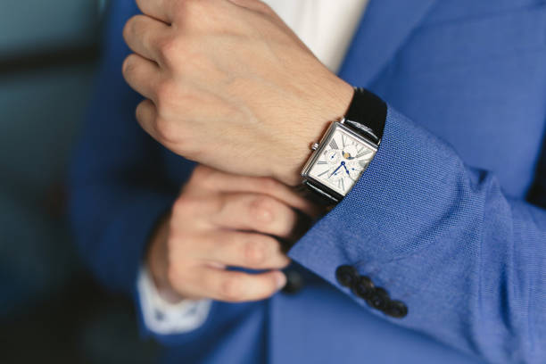 istock Close-up hands of the groom with a clock. 1391050214