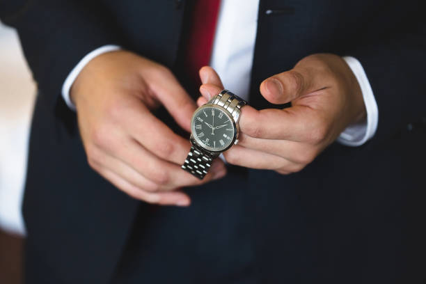 istock Close-up hands of the groom with a clock. 1391050219