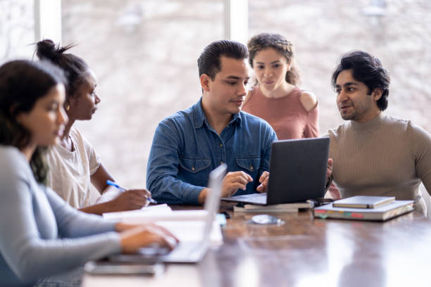 studenci pracują razem na laptopie - book working college student classroom zdjęcia i obrazy z banku zdjęć