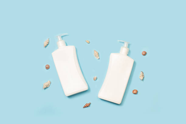 istock Sun tan lotion bottles and seashells on a light blue background 1391063009