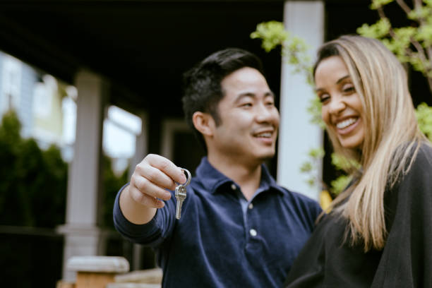 istock Multi-Ethnic Couple Holding Keys To New Home 1391063646