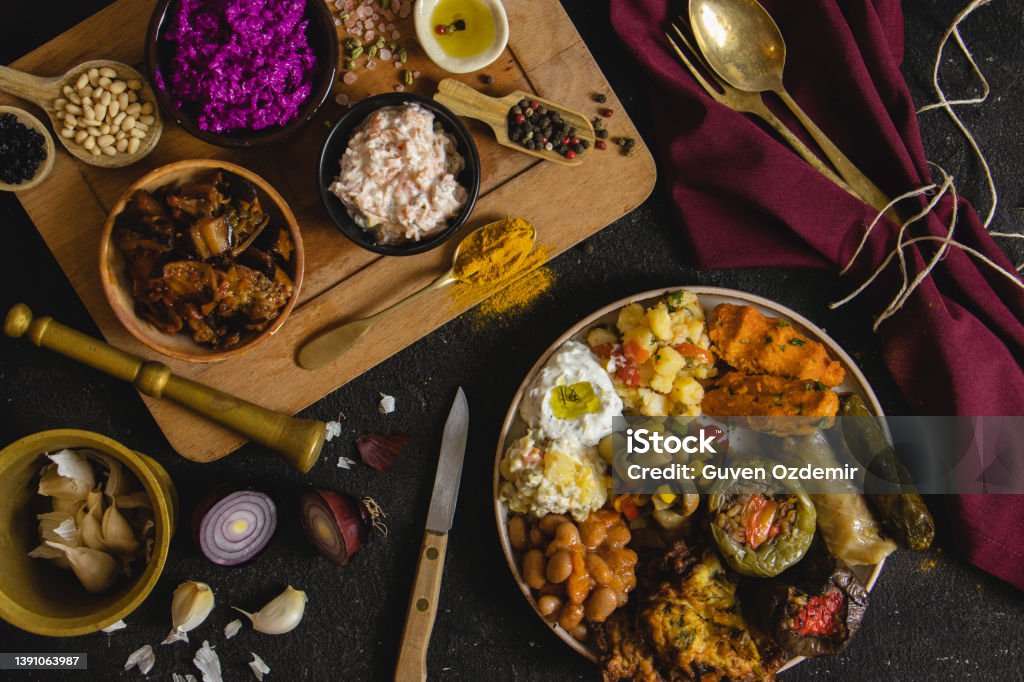 Traditional Turkish and Greek dinner meze table. Turkish Cuisine Cold Appetizers (appetizers with olive oil). Turkish appetizers in colorful plates. yogurt and various boiled herbs,  Traditional delicious Turkish foods, Yaprak sarmasi Meze Stock Photo