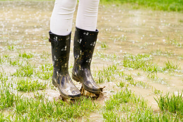 istock Close-up of wellingtons on rainy pound splashing with mud. 1391064775