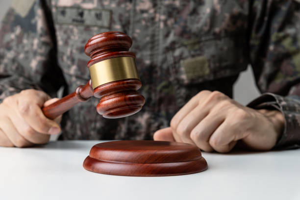 Hand of soldier holding gavel at courtroom. stock photo