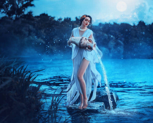 Fantasy woman Greek goddess zodiac sign Aquarius holds vintage earthenware jug in her hands and pours water into river. Background lake blue water, magic night, moon light stars. Astrology concept. Fantasy woman Greek goddess zodiac sign Aquarius holds vintage earthenware jug in her hands and pours water into river. Background lake blue water, magic night, moon light stars. Astrology concept virgo stock pictures, royalty-free photos & images