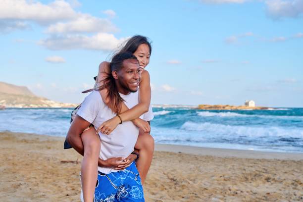 istock Happy young beautiful couple having fun on the beach, copy space 1391075838