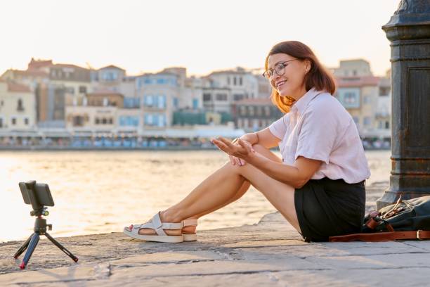 istock Woman recording stream on a smartphone on a tripod. 1391077361