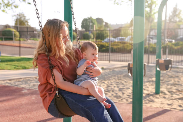 istock Mother sitting with daughter on a swing 1391082450