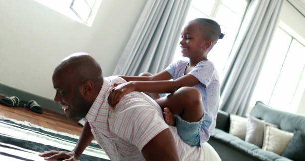 istock Father and child bonding together, dad doing push-ups with son in back 1391082591