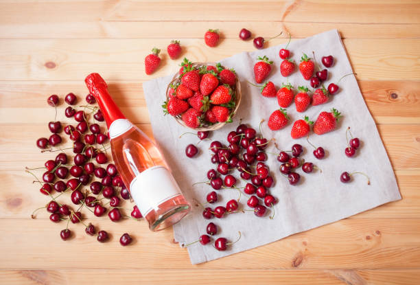 istock Rose champagne, fresh cherry and  strawberry on wooden table. 1391083797