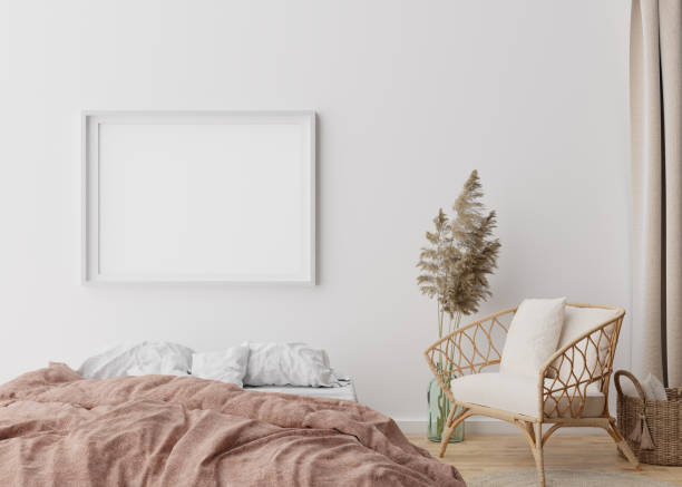 istock Empty picture frame on white wall in modern bedroom. Mock up interior in boho style. Free, copy space for your picture, poster. Bed, rattan armchair, pampas grass, parquet floor. 3D rendering. 1391084278
