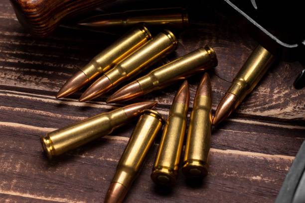 istock Bullets and Kalashnikov assault rifle on wooden background 1391085875