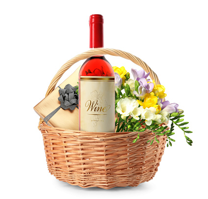 Wicker basket with gifts on white background