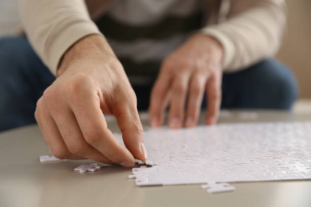 istock Man playing with puzzles at table, closeup 1391087060