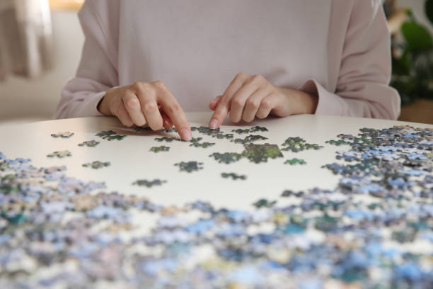istock Young woman playing with puzzles at table, closeup 1391087755