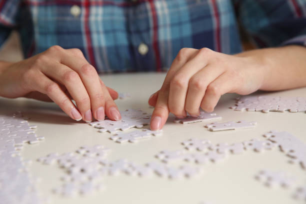 istock Young woman playing with puzzles at table, closeup 1391087803