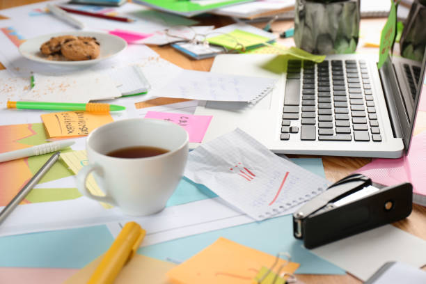 istock Messy table with laptop and tea. Concept of being overwhelmed by work 1391088117