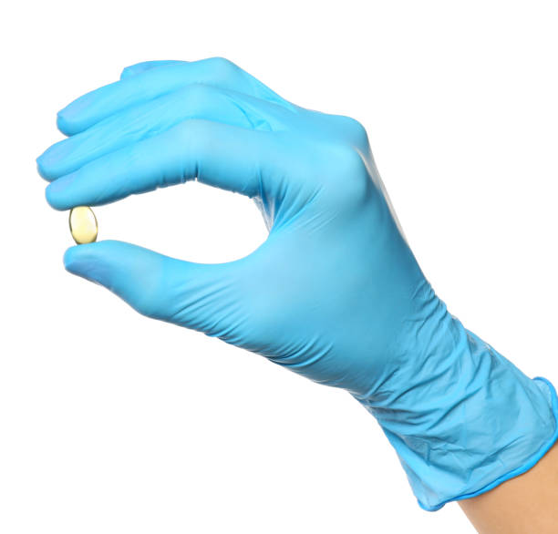 istock Scientist in protective gloves holding pill on white background, closeup 1391088312