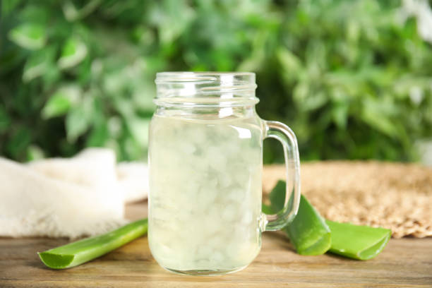 Fresh aloe drink in mason jar and leaves on wooden table Fresh aloe drink in mason jar and leaves on wooden table aloe juice stock pictures, royalty-free photos & images