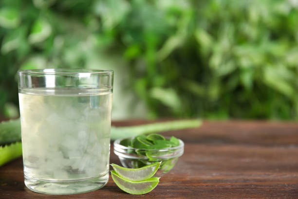 Fresh aloe drink in glass and leaves on wooden table, space for text Fresh aloe drink in glass and leaves on wooden table, space for text aloe juice stock pictures, royalty-free photos & images