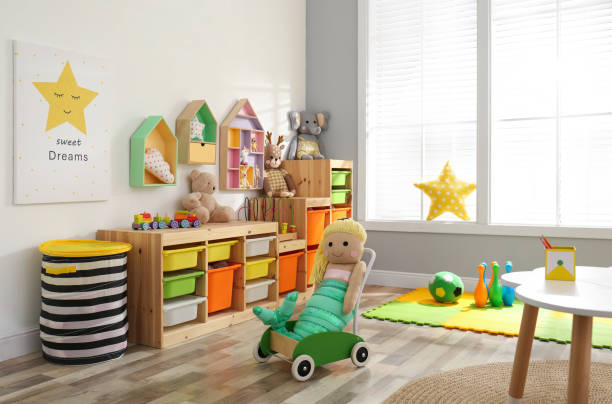 istock Stylish playroom interior with shelving unit and different soft toys 1391089571