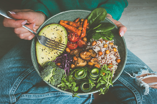 Woman eating vegan or vegetarian food. Vegan buddha bowl with fresh vegetables. Healthy vegan diet. High quality photo