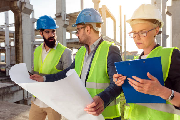 istock Group of architects looking at building plans on construction site 1391089876