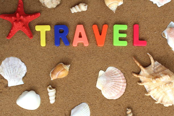 istock Abstract background from different seashells on the sand. Word. the journey is lined with colorful letters. 1391090511