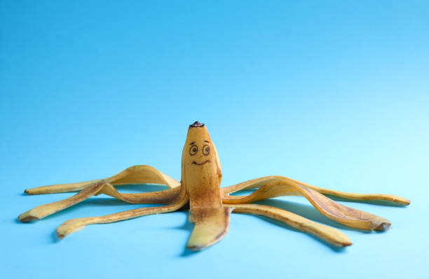 istock Banana peel with drawn happy face on light blue background 1391090649