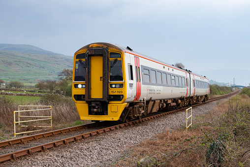 Tal-y-bont, Wales, UK - A Transport for Wales Class 158 diesel multiple unit passenger train between Barmouth and Porthmadog on the Cambrian Main Line.