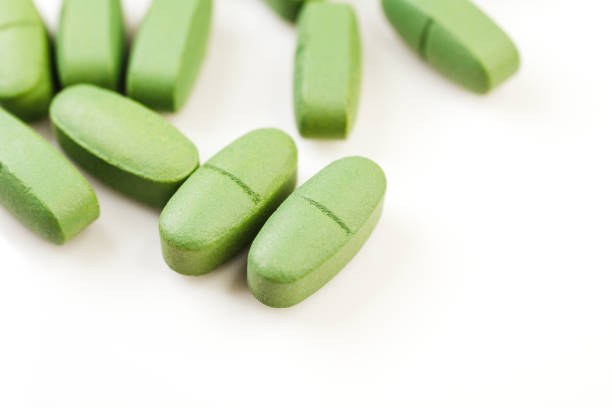 istock Green pain pills isolated on a white 1391092039