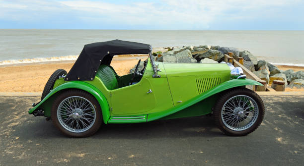 classic green mg sports car estacionado no passeio à beira-mar com praia e mar ao fundo. - british racing green - fotografias e filmes do acervo
