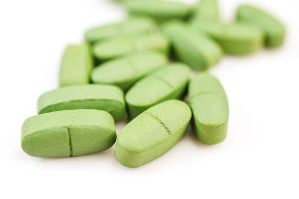 istock Green pain pills isolated on a white 1391092068