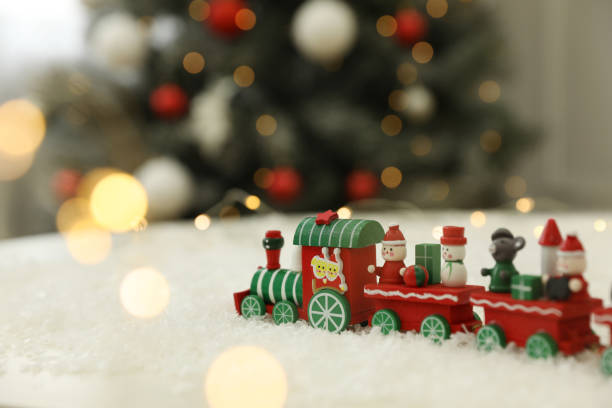istock Bright toy train on artificial snow in room with Christmas tree 1391095417