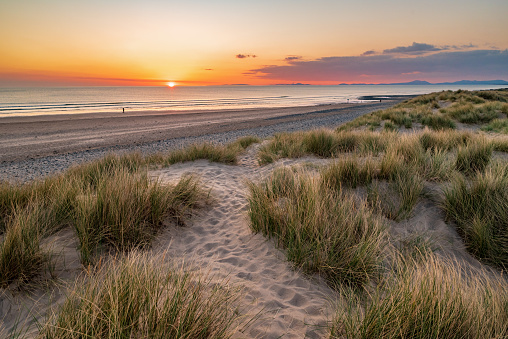 Wide angle view over sunset over the sand dunes at Barmouth Beach, Gwynedd, Wales, UK.