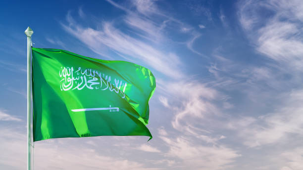 istock Saudi Arabia flag on flagpole against blue sky 1391095787
