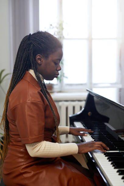 istock Woman playing on grand piano 1391097904