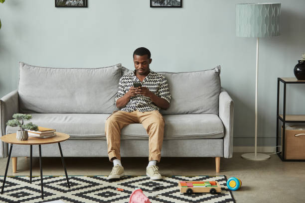 Minimal Portrait of African American Man at Home using Smartphone